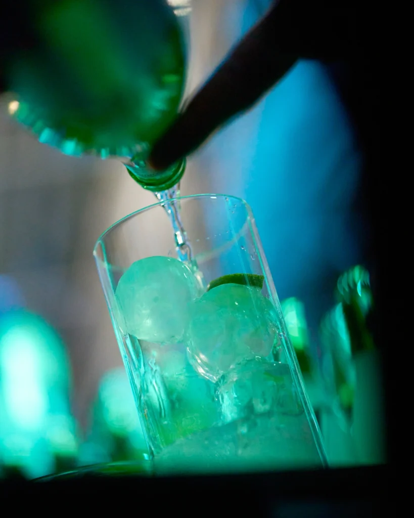 Cóctel con hielo sirviéndose en evento nocturno