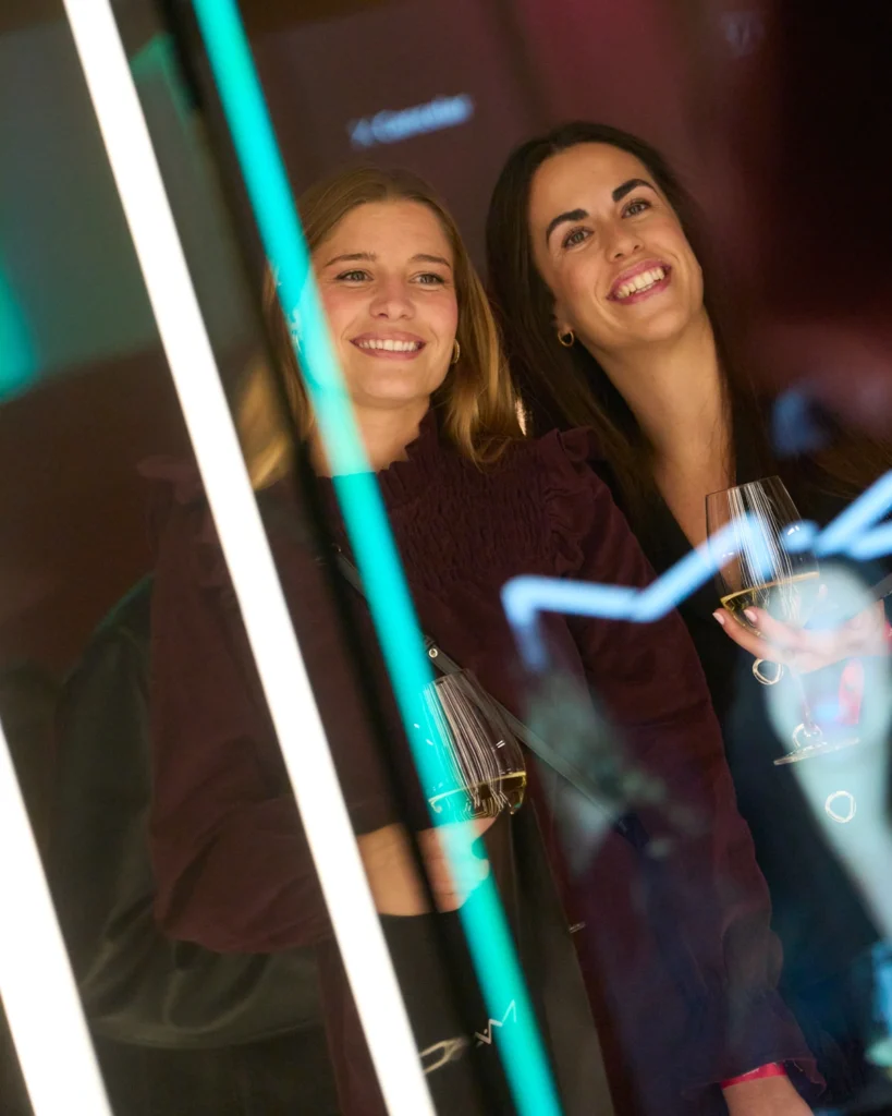 Dos mujeres con copa sonriendo en gala nocturna
