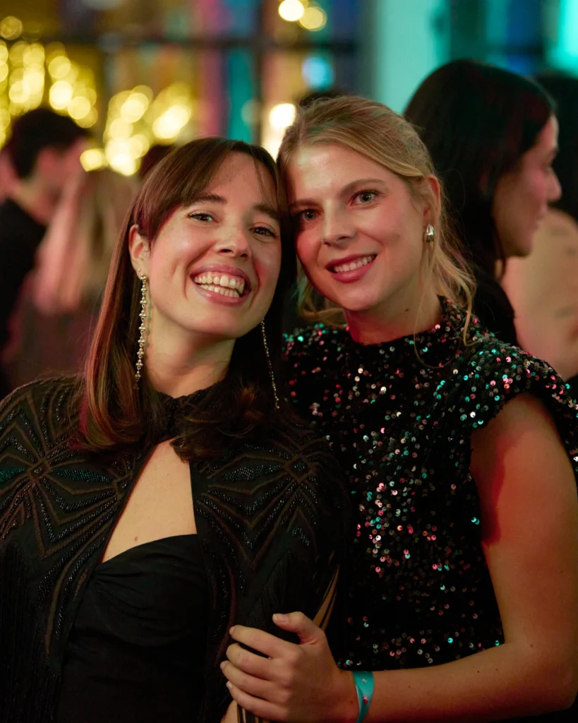 Dos mujeres sonriendo con vestido de gala en evento