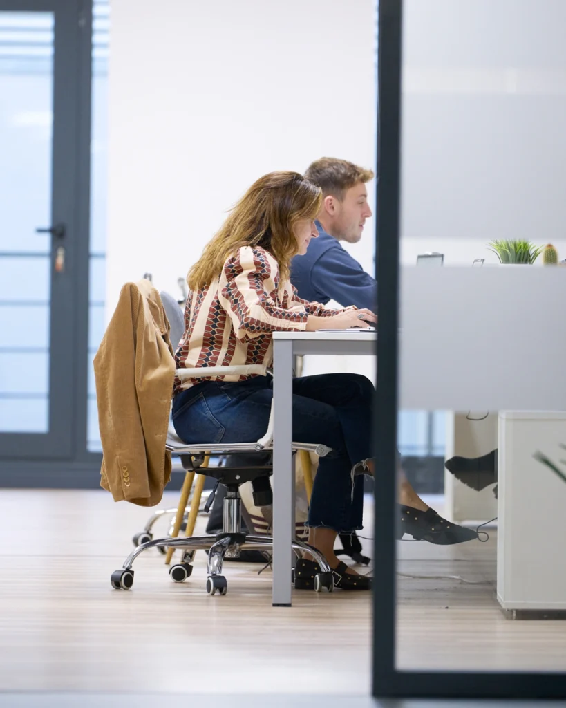 Fotografía corporativa en oficina — dos profesionales trabajando
