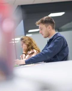 Hombre y mujer trabajando en oficina vista a través de cristal