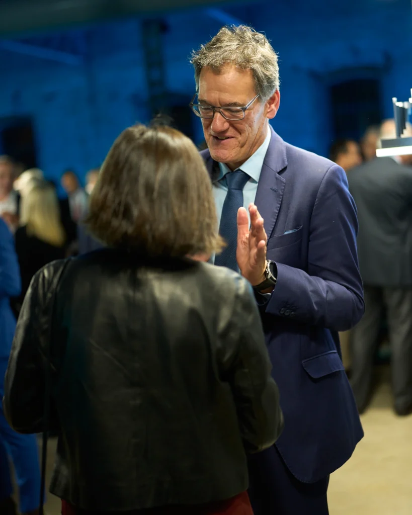 Hombre de traje conversando en evento corporativo