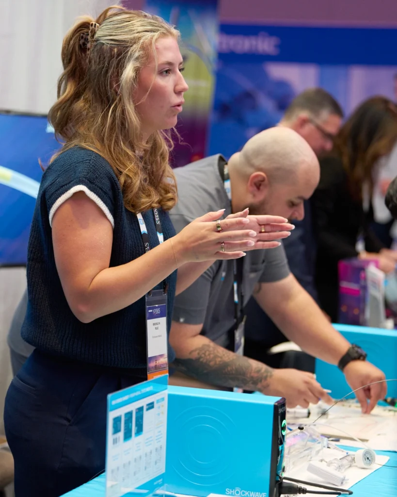 Mujer explicando en stand de congreso médico