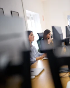Mujeres trabajando en ordenadores en oficina