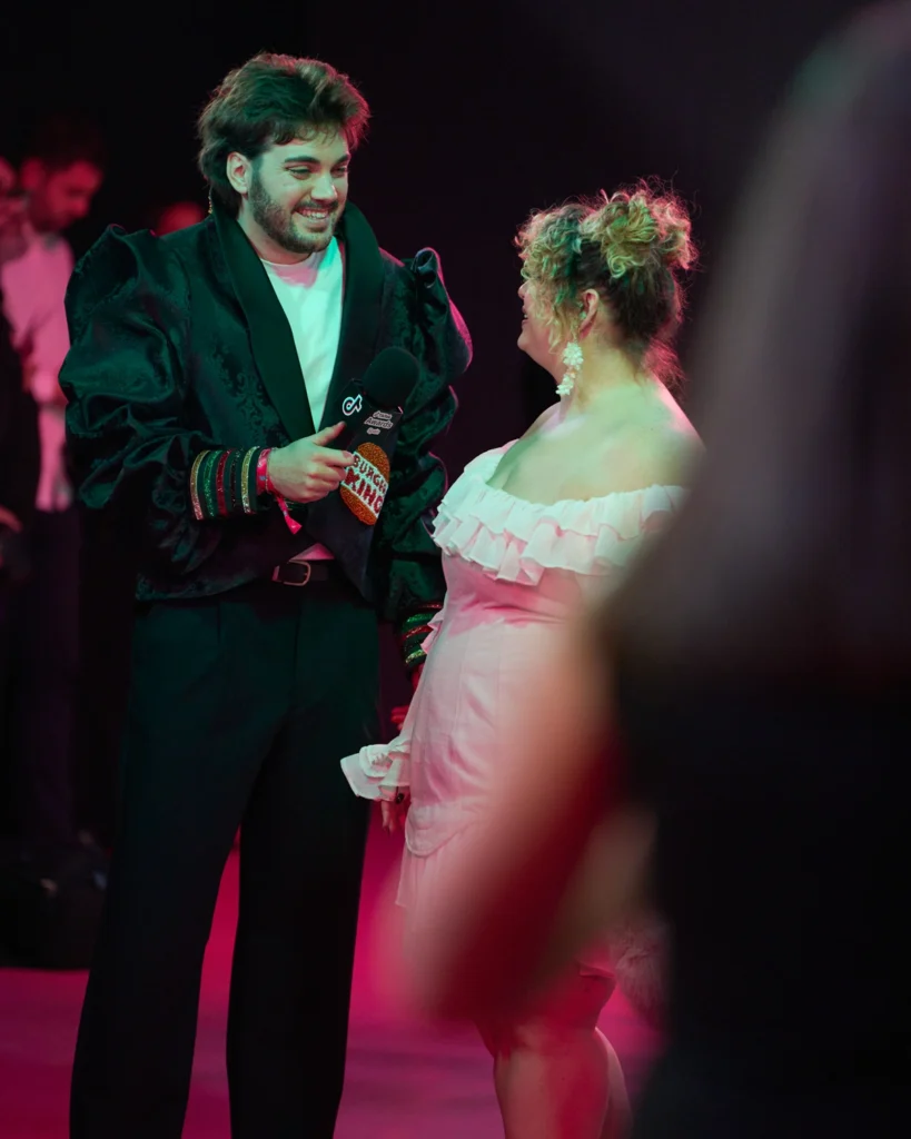 Pareja bailando en alfombra roja durante gala