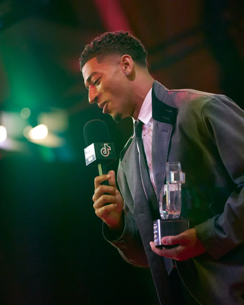 Presentador con micrófono y premio en TikTok Awards