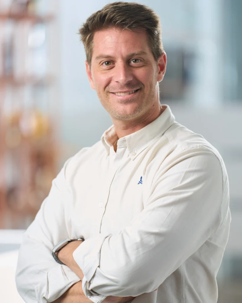 Retrato de hombre con camisa blanca y brazos cruzados
