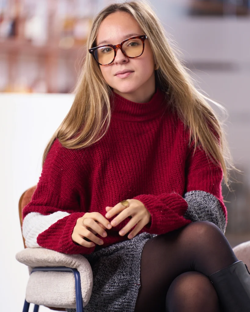 Retrato de mujer joven con gafas y jersey rojo